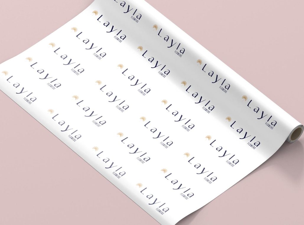White wrapping paper with a repeating Layla Flowers logo pattern