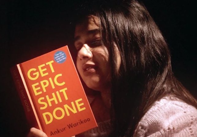 Cinematic film still of a girl holding a book in warm low light