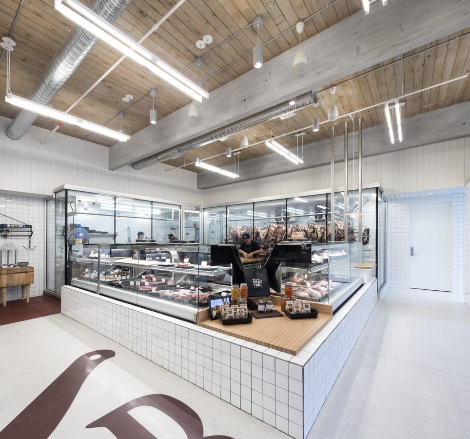 Bright white-tiled butchery interior with dry-aged meat counters